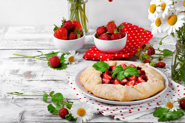 Shortbread galette with strawberry on the white wooden table