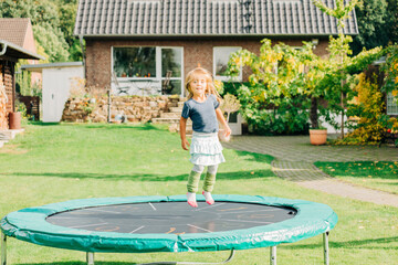 Toddler girl jumping on trampoline