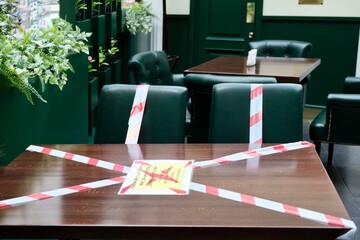 Cafe (cafeteria) in the pandemic. Work of cafes and restaurants with respect to social distance. Seating in the cafe. Tables and chairs in a cafe/restaurant with red-white tape.