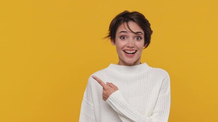 Smiling shocked fun young woman girl 20s years old in white sweater posing look camera pointing fingers hands on copy space workspace isolated on yellow background in studio. People lifestyle concept - Powered by Adobe
