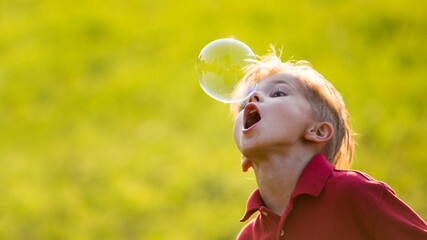 little boy blowing soap bubbles