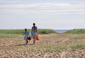 two young girls going to the sea by sand dune