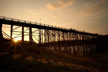 Fototapeta premium Sunset over the bridge cross the river at Sangkhlaburi, Kanchanaburi Attractions in Thailand