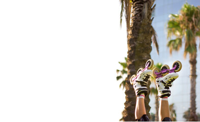 Girl's legs wearing socks and rollerskates upside down against a palm trees in the park. Space for text with white background. Sport can be fun