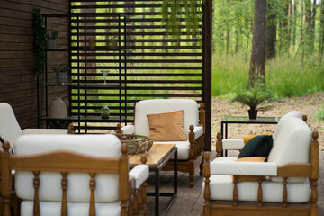 a white sofa with pillows stands on the veranda