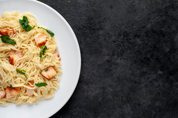 
salmon pasta on stone background with copy space for your text