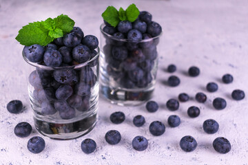 Blueberries in glass glasses on a white background.
Close-up.