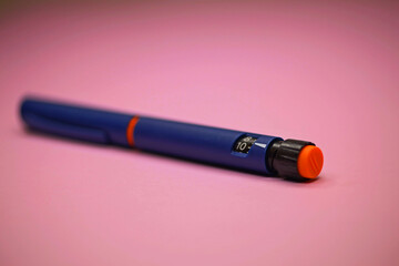 insulin pen, injector pen on a pink background. used to treat diabetes in insulin pens. Close-up, macro. selective focus.