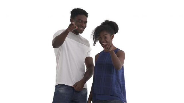 Portrait of attractive black couple pointing with index finger on camera indicating somebody or making someone feel included, nodding in approval isolated on white background