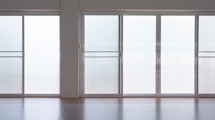 Front view of frosted glass sliding doors with screen doors and light reflection on tile floor...