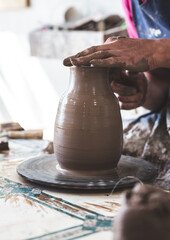 Potter hands making in clay on pottery wheel. Potter makes on the pottery wheel