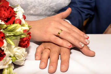 Obraz na płótnie Canvas Bride's palm with the wedding ring lies on the groom's palm