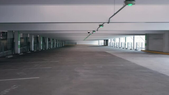 Industrial interior. Empty parking building during Coronavirus Covid-19 outbreak quarantine. 4K shutdown footage, California, USA. Driving through an empty parking garage building.