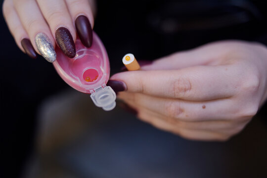 The Girl's Hands Hold Capsules For Cigarettes And Puts Them Into Cigarettes. Banning Flavored Tobacco. The Girl Will Buy, Plozie Habits, Bypassing The Rules.