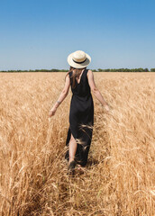 a girl in a hat in a wheat field