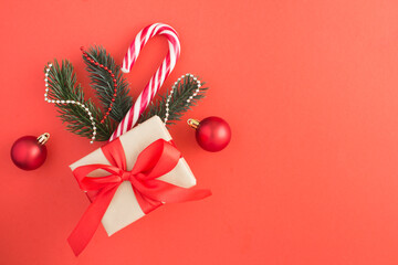 Christmas composition with a gift on the red background. Top view. Copy space.