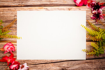 mockup blank paper sheet on a wooden background. flower border pink and green blossom, top view.. flat lay. pink tone.