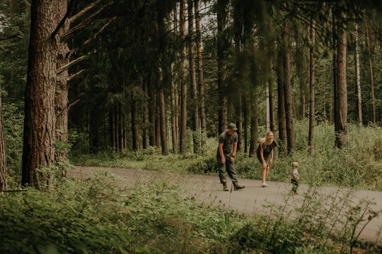 The family is walking in a pine forest. - Powered by Adobe