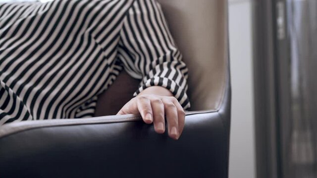 Slow motion fingers of young female business professional tapping on chair