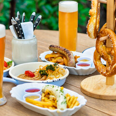 Beer with sausage, meat meal, pretzel, sauce on the table