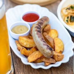 German sausage with fried potato, ketchup close up