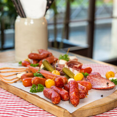 Sausage with cheese and fermented cucumbers, snacks on the table