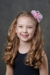 Portrait of a young long haired girl wearing rose hairband and looking at camera