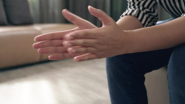 Slow Motion Closeup Of Female Hands Clapping While Sitting Down