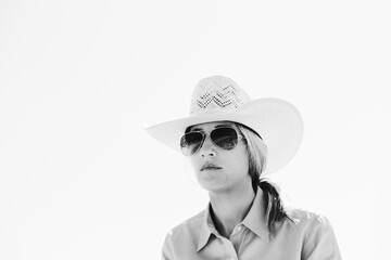 Western portrait of cowgirl in black and white wearing a cowboy hat close up, copy space on background.