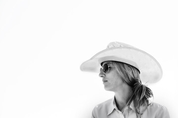 Cowgirl shows western lifestyle close up in cowboy hat and sunglasses, black and white portrait isolated on white background.