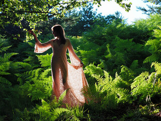 young lady between ferns in the forest