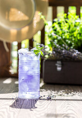 Lavender lemonade and ice cubes on a wooden table. Summer drink, iced tea.
