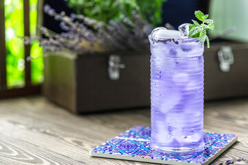 Lavender lemonade and ice cubes on a wooden table. Summer drink, iced tea.