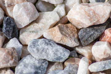 Raw rocks and minerals as natural stones background with crushed and rough material at a rough coast or rocky beach show nuggets and sandstones in harmonic pastel colors