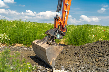The excavator spreads the ground on the field © edojob