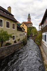 Fototapeta na wymiar český krumlov, czech republic. View to castle tower in the ancient bohemian village with antique houses. Landscape with blue sky and clouds