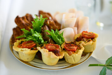 Party Appetizers. A plate of mini quiches and cold cut meats.