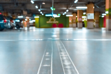 Garage car blurred. Car lot parking space in underground city garage. Empty road asphalt background in soft focus. Concrete skeleton for parking car.