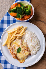Parmegiana Steak also known as Filet Parmegiana. .Accompanied by vegetable salad, rice and french fries