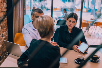 Business meeting with young couple and their financial advisor inside a cafe with the focus through a fence.