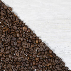 Grains of coffee on a background of bleached wood.