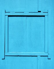 Blind or boarded up window on blue board shed wall