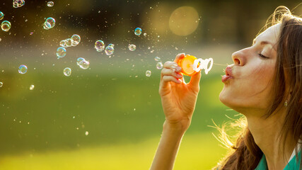 Beautiful girl blowing soap bubbles