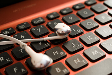White headphones on the laptop keyboard.  Headphones close up