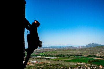 Rock climber climbing up a cliff