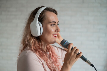 Close-up portrait of a caucasian woman with curly hair singing into a microphone. Beautiful sensual...