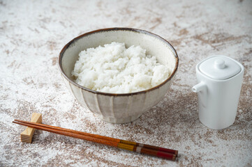 japanese white rice in a bowl with soy sauce bottle