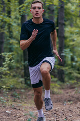 Close up picture of a handsome jogger jogging in the forest