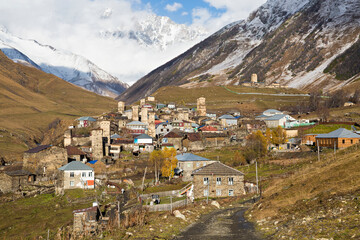 Mountain village Ushguli with medieval towers and one of the peaks of the Caucasus Mountains, Mount Shkhara in the background, Georgia, Caucasus