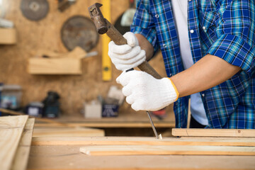 The carpenter is using a hammer to chisel To trim wood